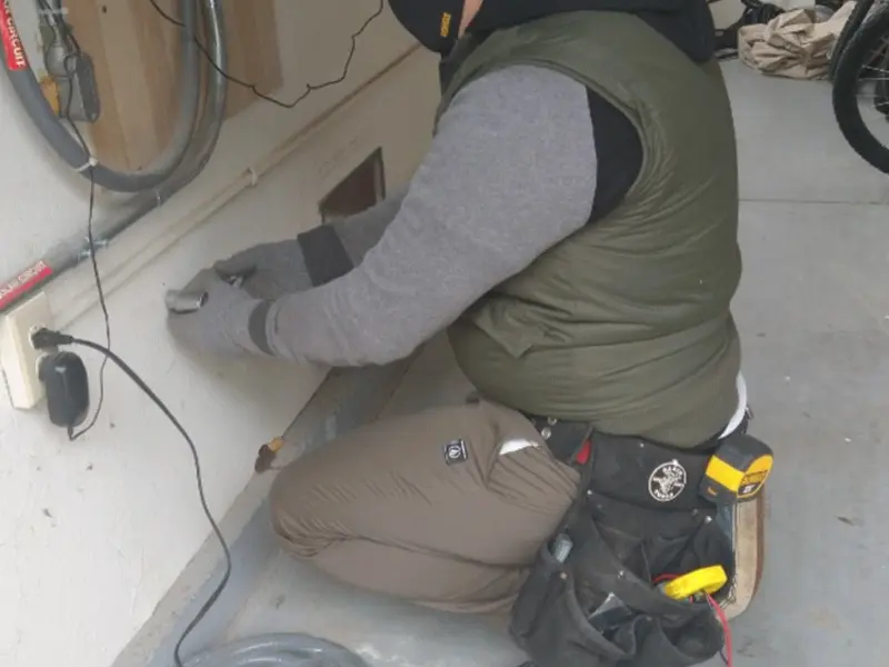 Electrician performing outlet wiring in a New Garden garage